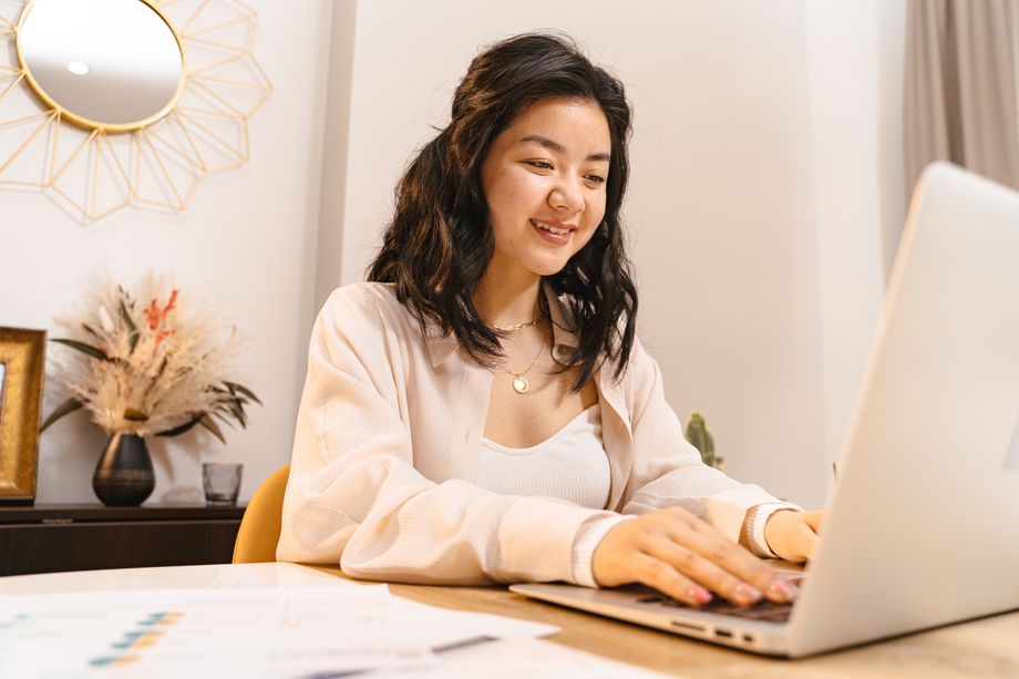 Studentkinja zadovoljno pregleda materijal na laptopu