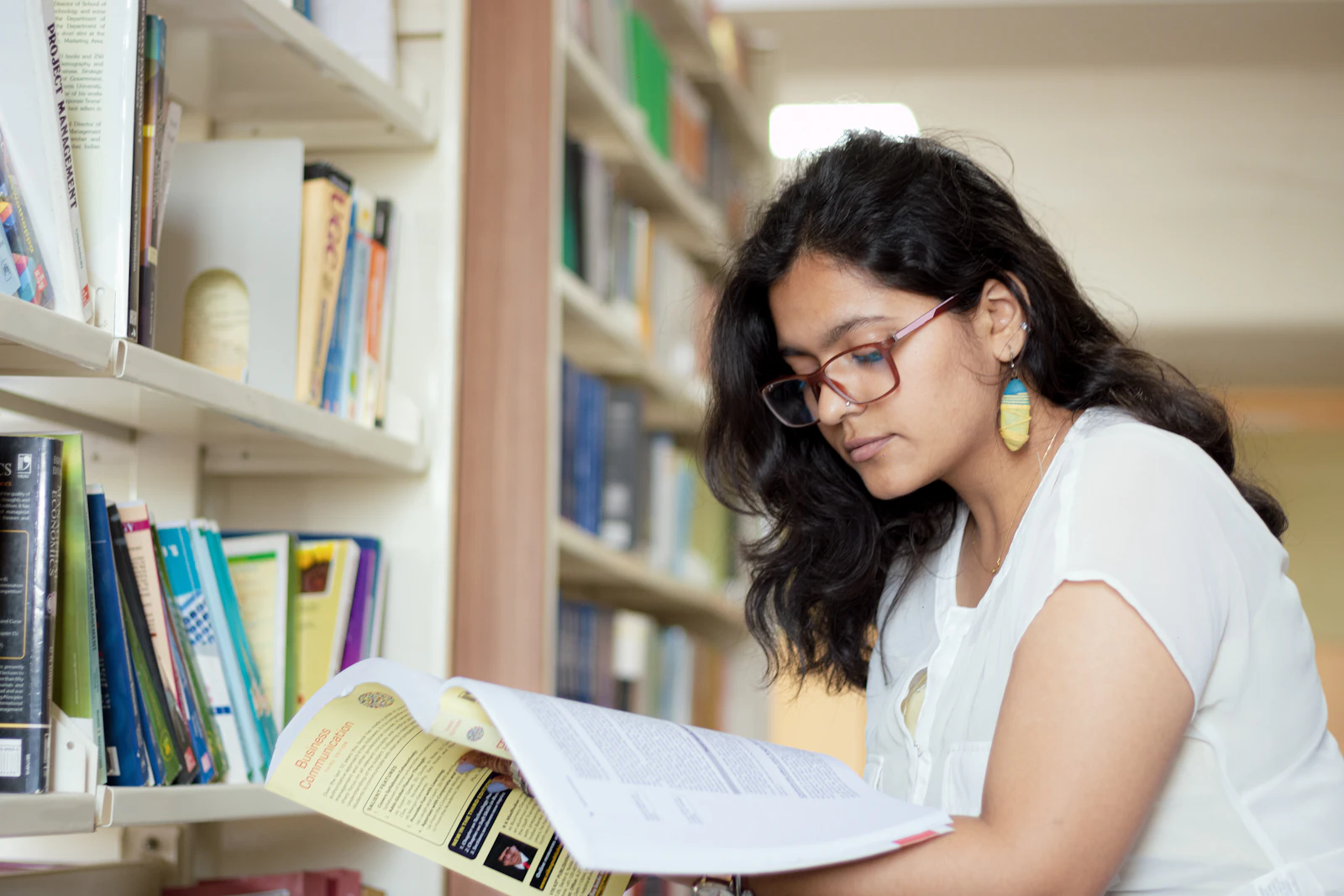 Studentkinja istražuje literaturu u biblioteci